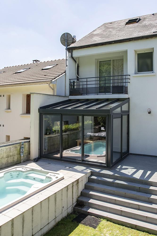Réalisation de véranda avec toit en verre et abri de piscine bas à Velizey Villacoublay vue de l'extérieur